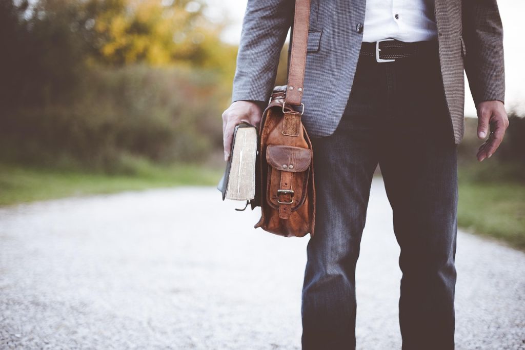 Homme avec un sac en cuir et un livre