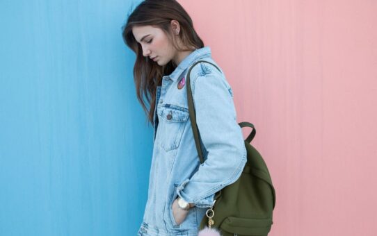 Femme avec veste en jean et sac à dos
