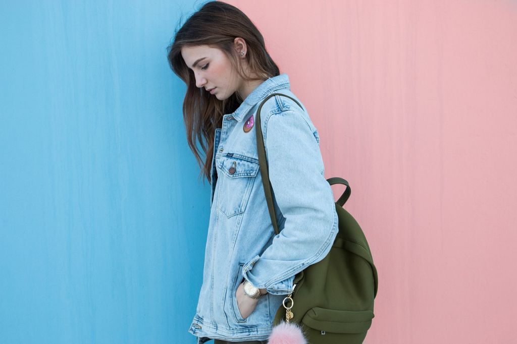 Femme avec veste en jean et sac à dos